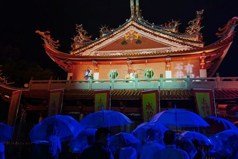 兩岸嘉賓在雨中觀看行進式情景演繹。中新社