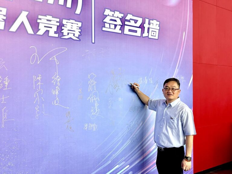 6月13日，福州大學物理與信息工程學院微電子系教授王量弘在第二屆海峽兩岸（福州）人工智能一工業機器人競賽的簽名牆上簽下自己的姓名。