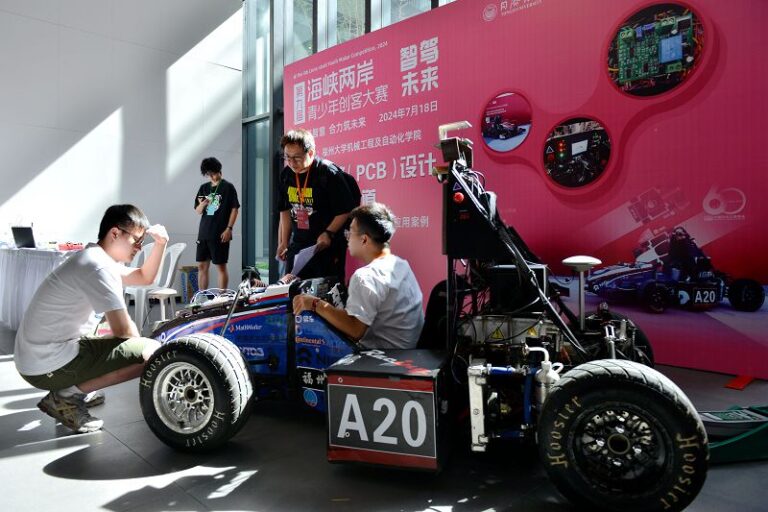 7月18日，第九屆海峽兩岸青少年創客大賽福州區賽事現場，台灣逢甲大學助理教授洪百賢（右二）正在為集成電路（PCB）設計與製作分賽道參賽團隊評分。 中新社