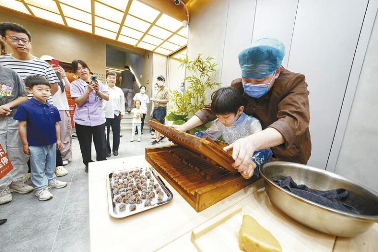 64a在新設的互動體驗區，小朋友體驗中藥炮製。