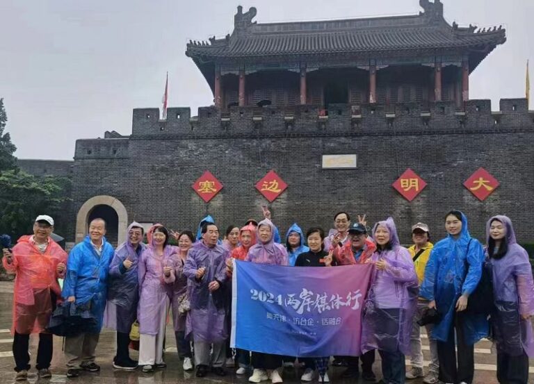 2024津台會兩岸媒體精彩行，從天津薊縣黃崖關長城展開熱身，大夥在煙雨灰灰中披著輕便雨衣留下汗雨淋漓的合照。(記者劉治強攝影)