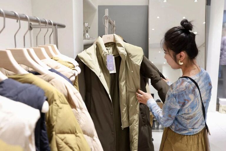 近日，一位客商在平湖中國服裝城內挑選羽絨服。