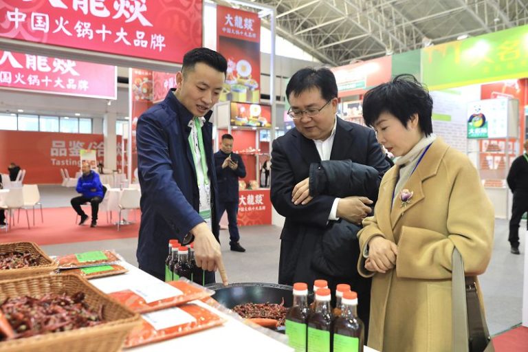 1月26日，第二屆中國國際供應鏈促進博覽會在北京開幕，圖為川渝火鍋產業供應鏈展區一名展商為觀眾介紹火鍋鍋底。 中新社
