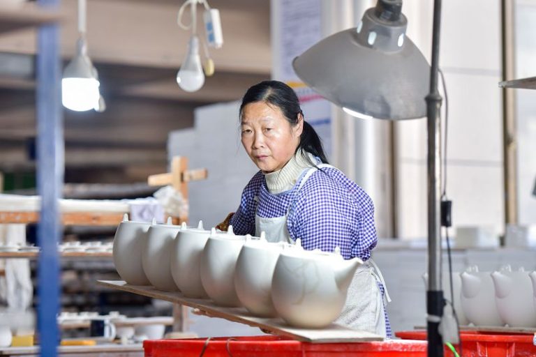 1月17日，在德化縣城東工業區中外合資企業東福陶瓷有限公司內，工人們忙著搬運陶瓷素坯。