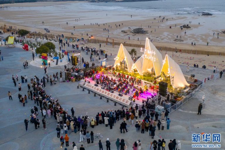 1月1日清晨，泉州石獅紅塔灣海岸公園，交響樂團在演奏樂曲，吸引很多市民、遊客前來欣賞。人們在歡快的樂曲聲中，迎接新年的到來（無人機照片）。新華網