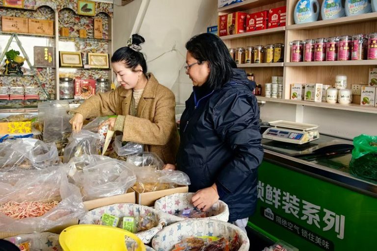 1月21日，在福州連江縣黃岐鎮一家海鮮干品店內，馬祖鄉親曹雅慧（右）正在採購年貨。 中新社