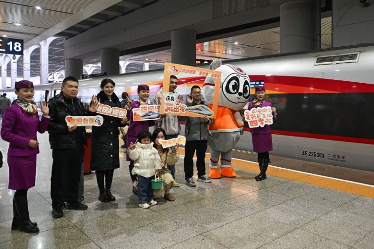 2024年12月24日，旅客在重慶西站與開往成都東的G8608次復興號動車組合影留念。中新社