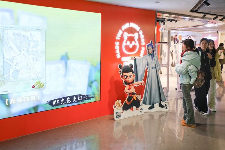 2月19日，遊客在重慶市江北區觀音橋「方圓LIVE」駐足欣賞《哪吒之魔童鬧海》的相關角色立牌。