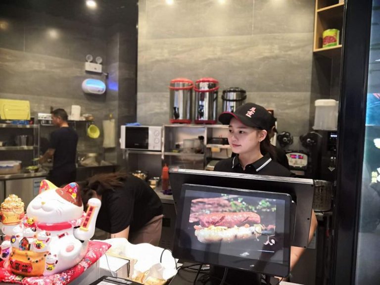 台灣青年楊喬米在小吃店內為顧客點餐。