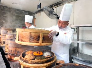 圖為王軍（右）和同事楊善虎在烹製「九大碗」菜品。 中新社