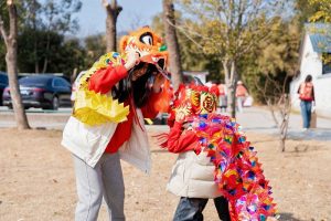 2月18日，蘇州市吳中區旺山，兩岸婚姻家庭的母子一起戴著舞獅道具嬉戲。 中新社