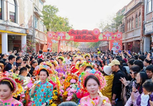 2月19日，福建泉州開啟「迎番貨」踩街活動。圖為頭戴「簪花圍」的蟳埔女挑擔沿街售賣。
