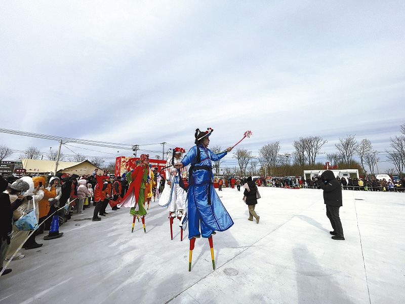 53h非遺傳承人楊建樹身著一身藍衣，在永樂店大集上表演高蹺。