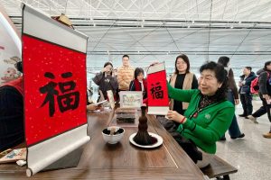 旅客體驗天津楊柳青木版年畫福字拓印。 中新社