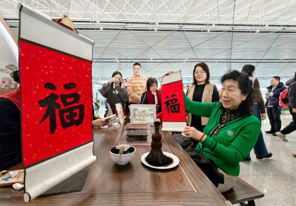 旅客體驗天津楊柳青木版年畫福字拓印。 中新社