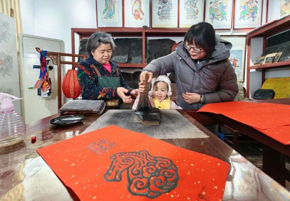 月11日，天津楊柳青古鎮，遊客在「玉成號」畫莊體驗馬年主題木版年畫拓印。中新社