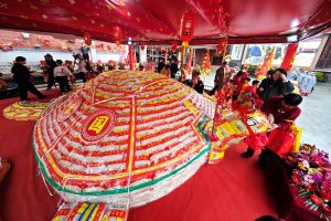 3月1日，福建泉州霞洲媽祖宮與台灣澎湖天后宮攜手舉辦「平安米龜、水果龍」揭彩祈福儀式。圖為民眾摸遍「米龜」全身祈福。中新社