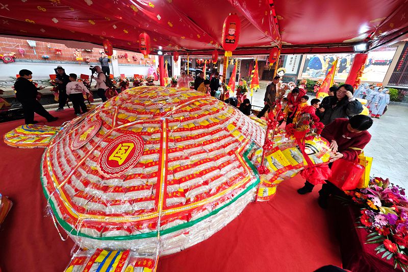 3月1日，福建泉州霞洲媽祖宮與台灣澎湖天后宮攜手舉辦「平安米龜、水果龍」揭彩祈福儀式。圖為民眾摸遍「米龜」全身祈福。中新社