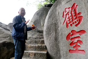 3月27日，七旬老者黃永樂在福建省漳州市龍文區雲洞岩景區向參觀者講述摩崖石刻的文化故事。中新社
