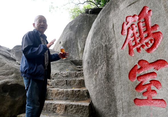 3月27日，七旬老者黃永樂在福建省漳州市龍文區雲洞岩景區向參觀者講述摩崖石刻的文化故事。中新社