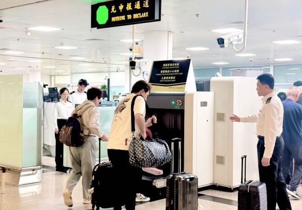 圖為廈門機場海關關員引導入境旅客快速通關。