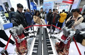 圖為彈鋼琴的人形機器人吸引參觀者。 中新社