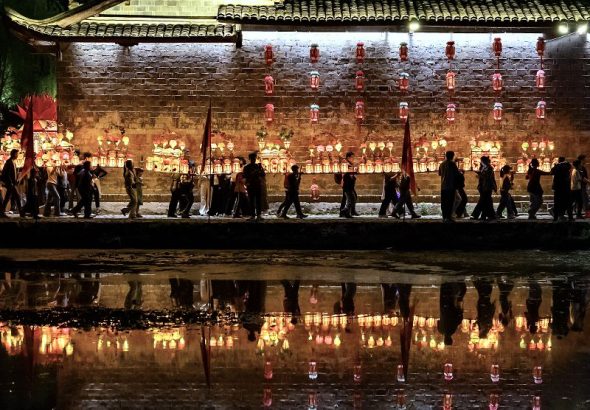 圖為村民們抬著各種造型的燈籠穿行在古村落裡。