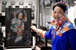 4月15日，身著傳統惠安女服飾的張秋霞在位於福建省惠安縣的工作室介紹她的影雕作品。中新社