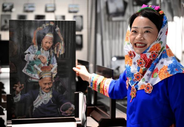 4月15日，身著傳統惠安女服飾的張秋霞在位於福建省惠安縣的工作室介紹她的影雕作品。中新社