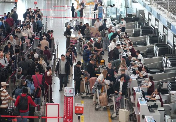 4月28日，首都機場T3航站樓內眾多旅客在排隊值機。「五一」假期臨近，北京首都國際機場旅客出行熱度顯著上昇。（首都機場供圖）