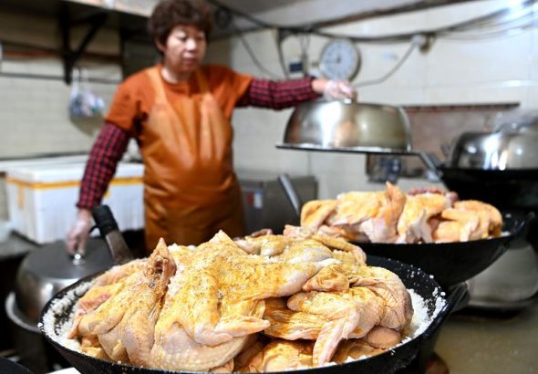 圖為塗抹好秘製醬料的雞放在鋪有粗鹽的鍋內。