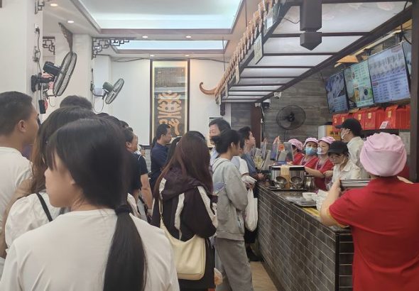 5月1日，海內外遊客在梧州冰泉豆漿館排隊點單。