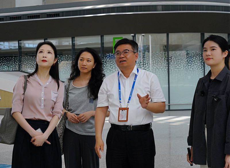 翔業集團旗下兆翔機場建設副總經理兼總工程師葛紅斌 （右二）向《台灣導報》全媒體中心策劃總監吳丹（左一）介紹翔安國際機場設計中融入的古厝、龍舟等兩岸共同文化元素