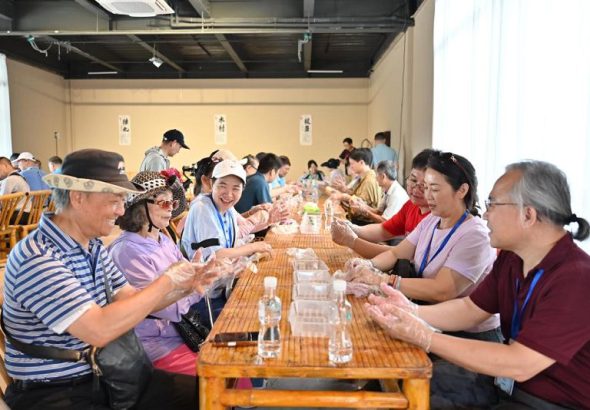 6月26日，兩岸客家鄉親同遊位於廣東河源的客家古村落南園古村，共同製作、品嚐客家美食油果。圖為兩岸客家鄉親製作客家美食。 中新社