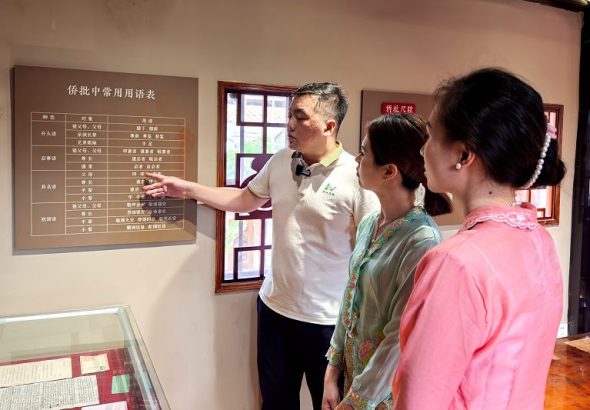 6月4日，福建泉州洛陽橋畔的洛江區僑批館吸引遊客參觀體驗，洛江區文旅講解員駱瑞祥（左）為遊客介紹僑批常用詞用法。中新社