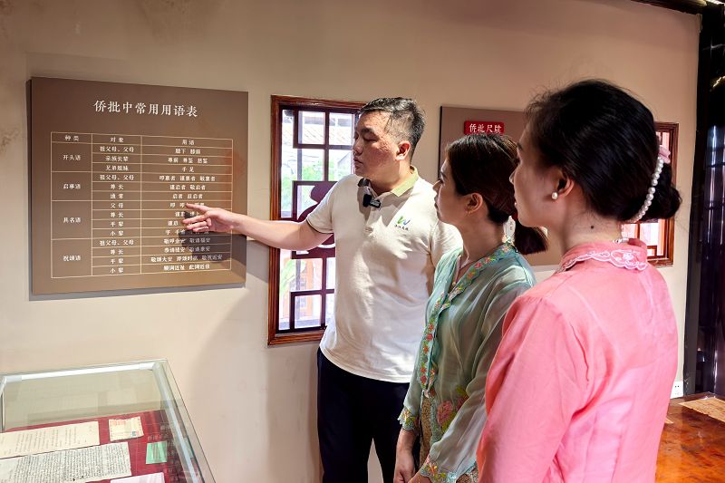 6月4日，福建泉州洛陽橋畔的洛江區僑批館吸引遊客參觀體驗，洛江區文旅講解員駱瑞祥（左）為遊客介紹僑批常用詞用法。中新社