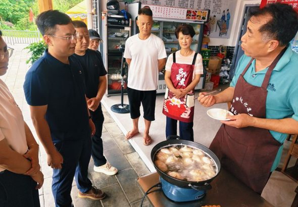 張振健（右一）在福建南平仁壽鎮為大家講解灌蛋製作。中新社