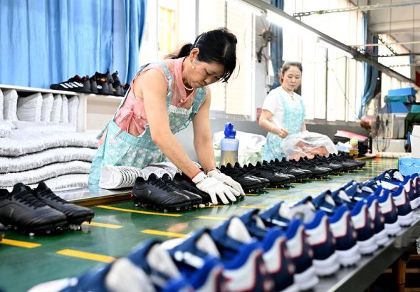車間員工進行成品鞋子的品控檢測。