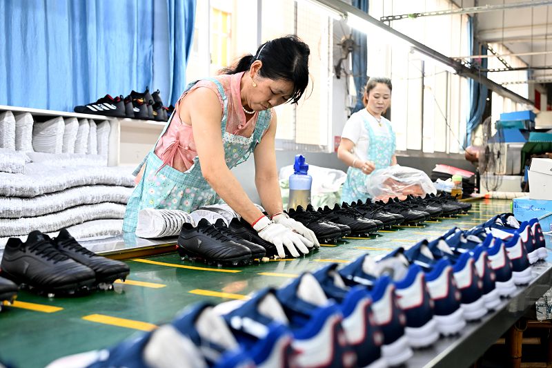 車間員工進行成品鞋子的品控檢測。