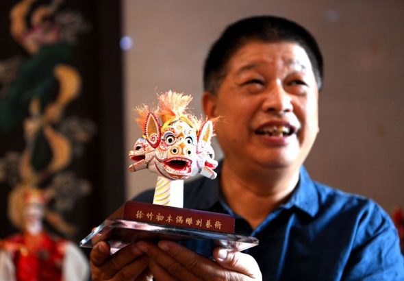 7月1日，在福建漳州古城的徐竹初木偶藝術館內，徐強向中新社記者介紹他的木偶頭雕刻故事。中新社