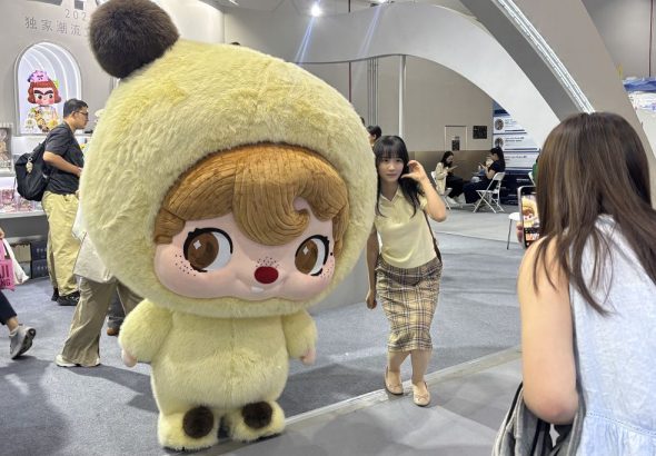 9月10日，2026年中國國際服務貿易交易會上，觀眾在52TOYS展區和人偶合照。中新社