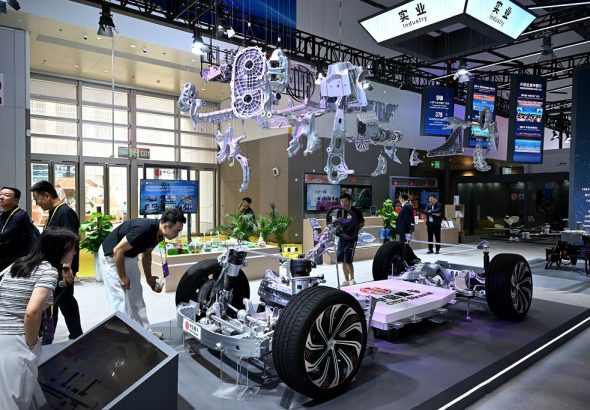 圖為新能源汽車一體化壓鑄輕量化鋁合金零部件吸引參觀者。 中新社