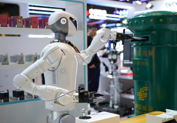 在服貿會電信、電腦和資訊服務專題展區，機器人為函加蓋郵遞漸進後投入信筒。