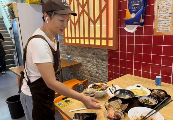10月1日，在江西南昌經開區「呷霸味台灣小吃」店內，台胞萬麗文給客人上菜。