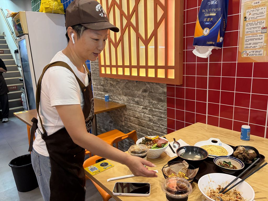 10月1日，在江西南昌經開區「呷霸味台灣小吃」店內，台胞萬麗文給客人上菜。